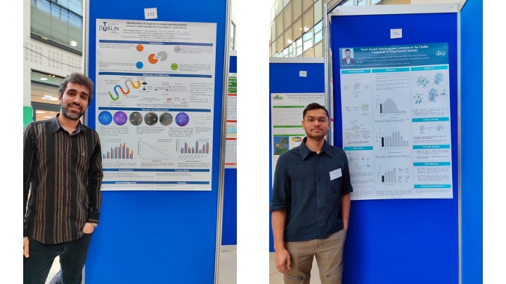 Two students in front of their posters at an academic research conference.