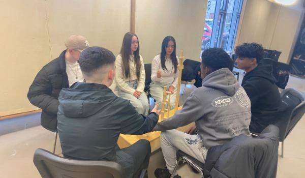 5th year students, boys and girls, sitting around table building a tower with wooden blocks