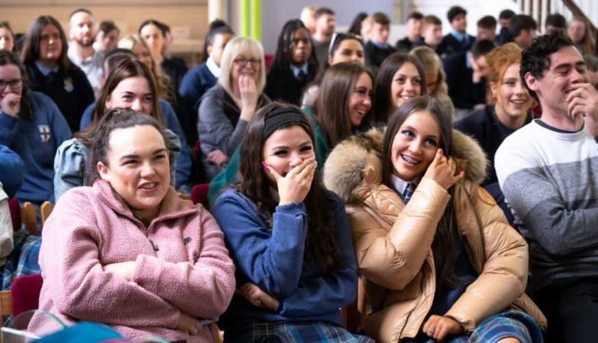 students laughing sitting watching video.