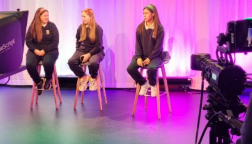 Three TY students sitting in front of camera in recording studio