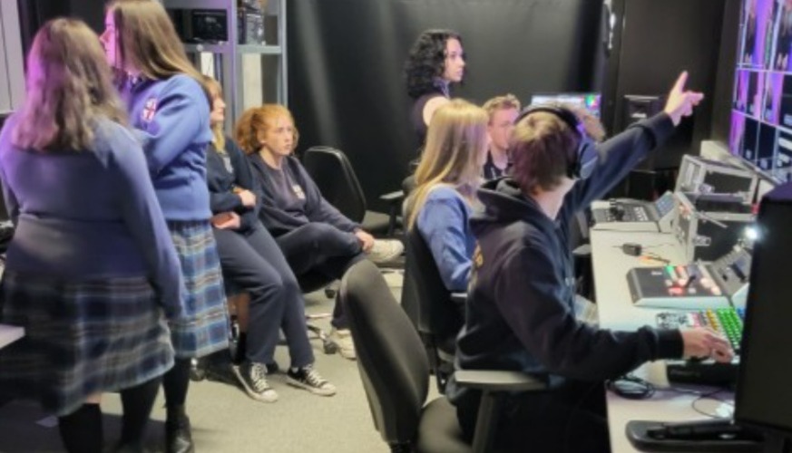 TY students sitting in recording studio control room in front of screens