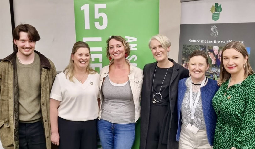 six people posed in front of pull up SDG banners