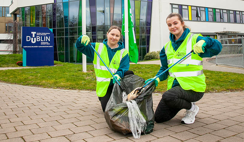 two girls wearing hi vis vests litter picking