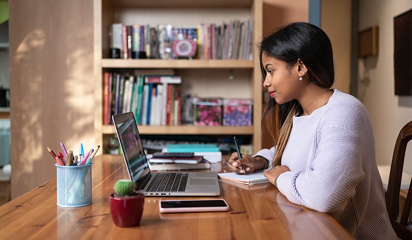 Girl at a laptop in a home setting learning online