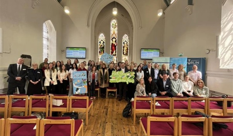 Group picture of all in attenance at seminar standing in Church venue.Some hold healthy campus signs