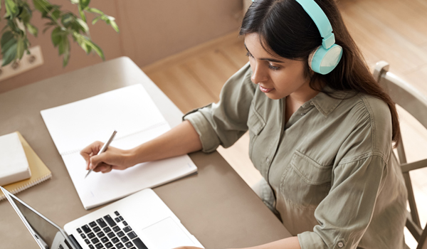 Student studying at a desk with headphones on