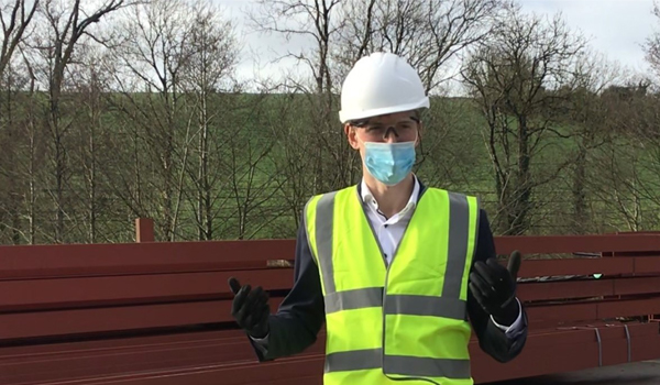 Builder wearing a hard hat and a mask