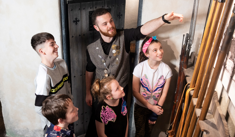 staff showing children around visitor attraction