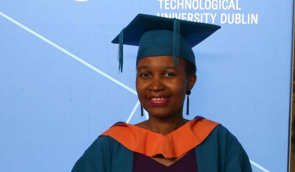 A smiling TU Dublin graduate in their robes