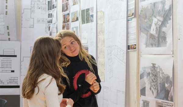 Photo of two female TU Dublin students looking at architectural drawings