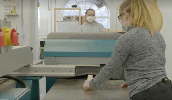 Two female apprentices using a thicknesser