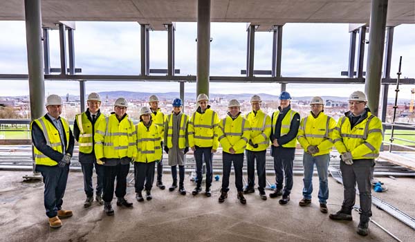 A group of people wearing reflective gear and hard hats on a building site