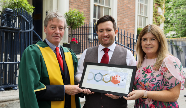 A group of people holding a framed award