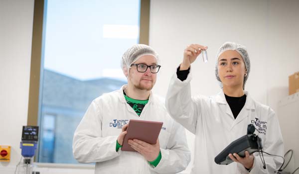 People in lab coats looking at a test tube