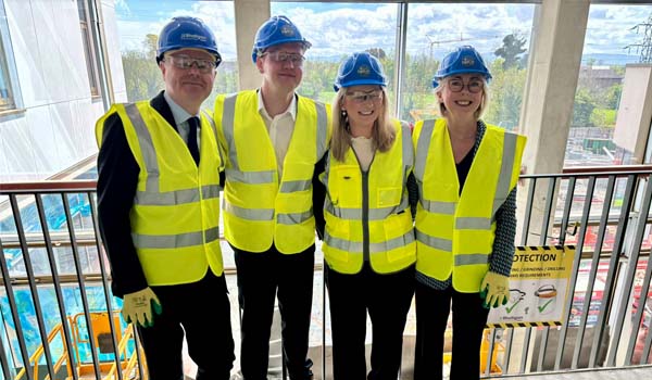 A group of people wearing hard hats and hi-vis vests