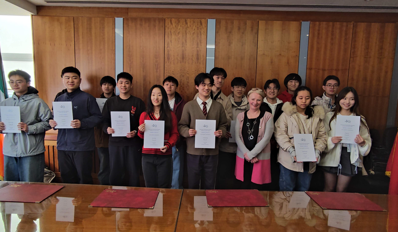 A group of students smiling and holding certificates