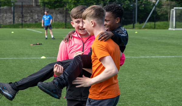 A group of children playing on a sports field in Grangegorman