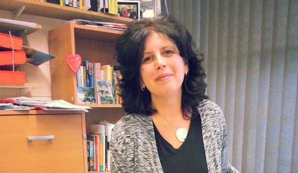 A person in an office in front of a book shelf