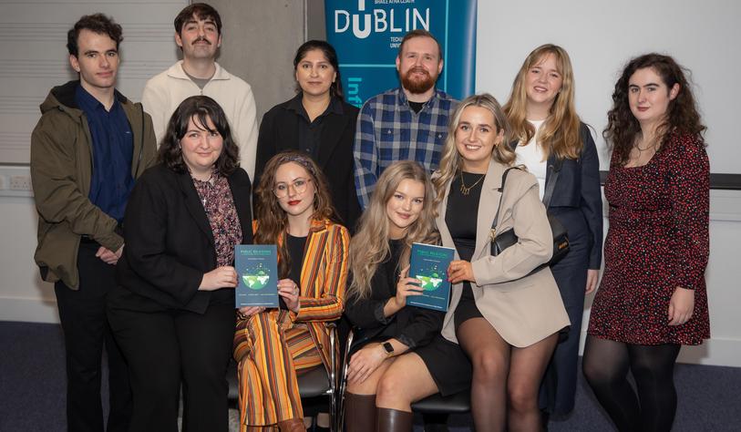 A group of people holding a book